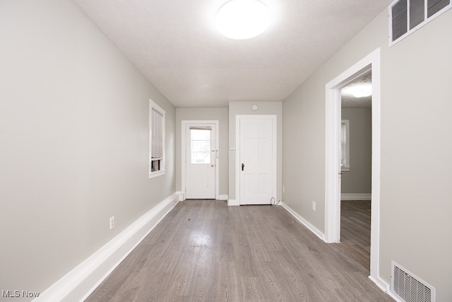 foyer entrance featuring a textured ceiling and light wood-type flooring