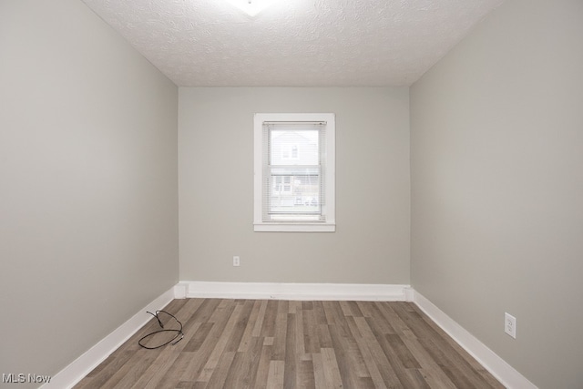 unfurnished room featuring hardwood / wood-style flooring and a textured ceiling