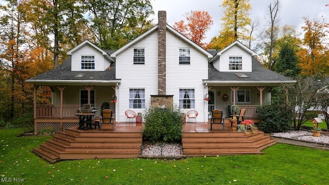 back of property featuring a wooden deck and a yard