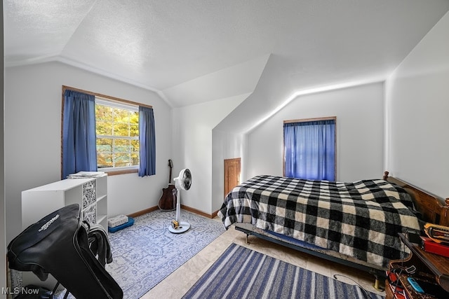 bedroom featuring vaulted ceiling and a textured ceiling