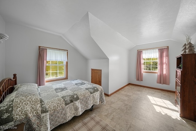 bedroom featuring lofted ceiling and a textured ceiling