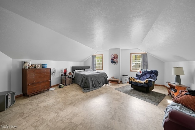 bedroom featuring vaulted ceiling and a textured ceiling