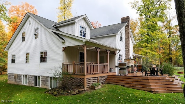 back of house with a wooden deck, a yard, and ceiling fan