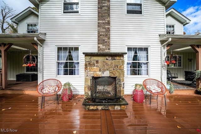 wooden deck featuring an outdoor stone fireplace