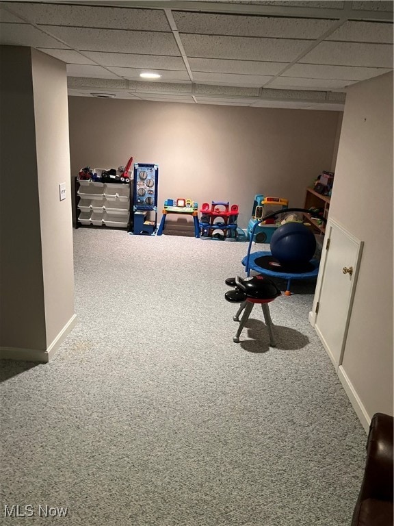 recreation room featuring carpet flooring and a paneled ceiling