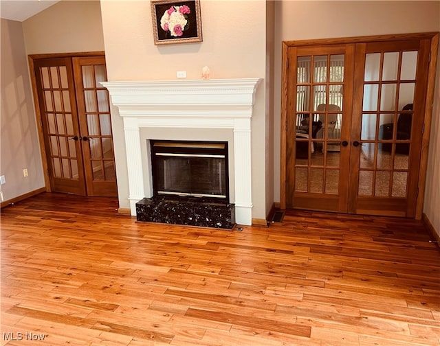 unfurnished living room featuring hardwood / wood-style floors and french doors