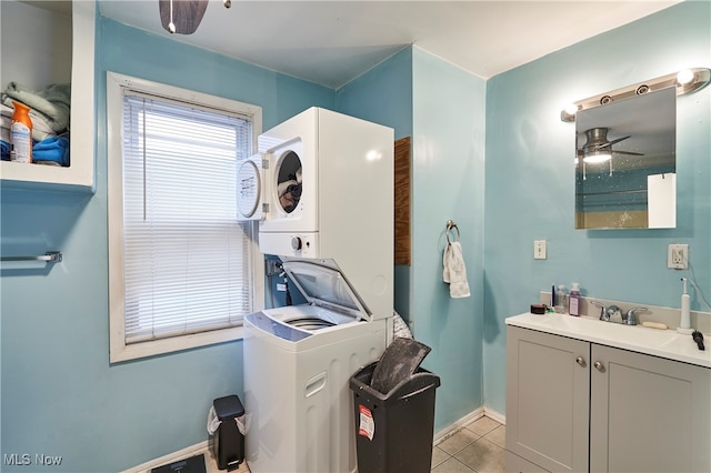 laundry room featuring sink, stacked washer and dryer, ceiling fan, and light tile patterned floors