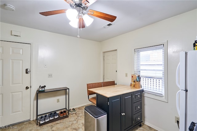 kitchen featuring wood counters, ceiling fan, and white refrigerator