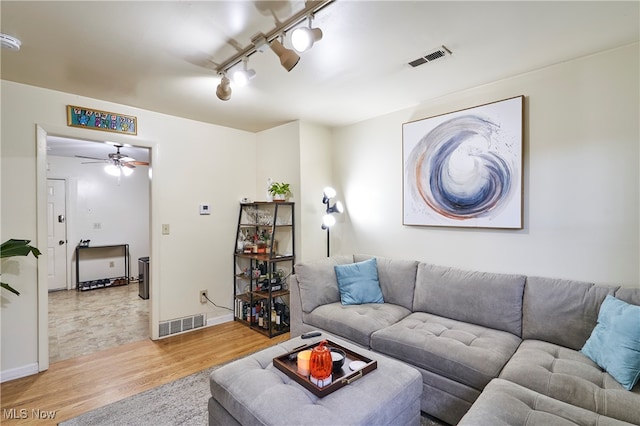 living room with rail lighting, ceiling fan, and light hardwood / wood-style flooring