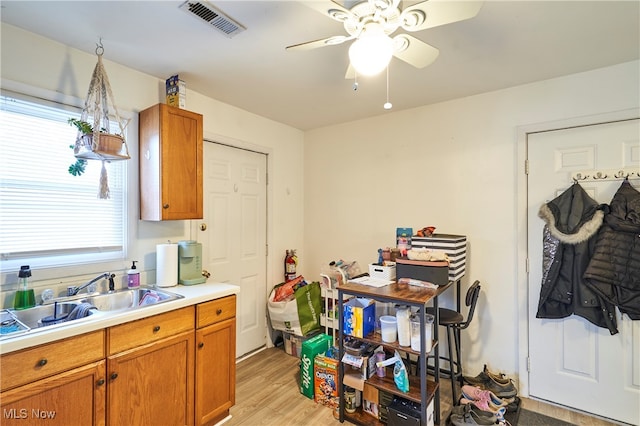 kitchen with light hardwood / wood-style flooring, sink, and ceiling fan