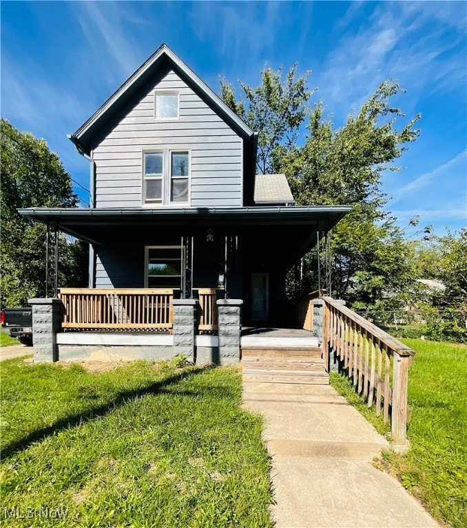 country-style home featuring covered porch and a front yard