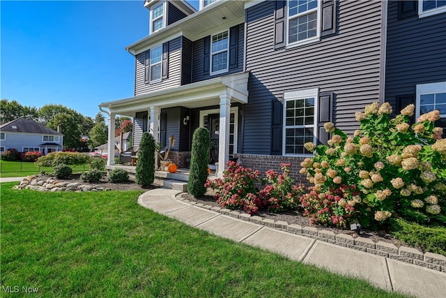 view of front facade with covered porch and a front yard