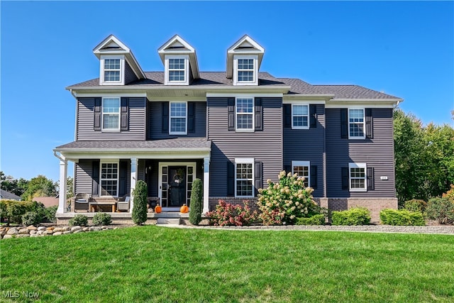 view of front of home with covered porch and a front lawn