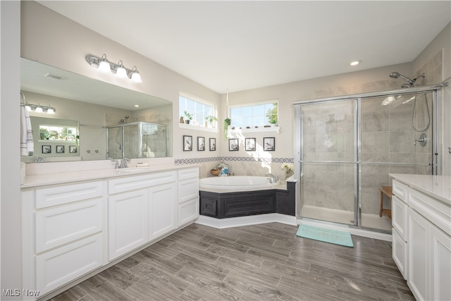 bathroom with vanity, separate shower and tub, and hardwood / wood-style flooring