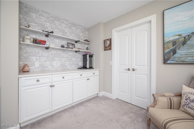 bar featuring light carpet and white cabinetry