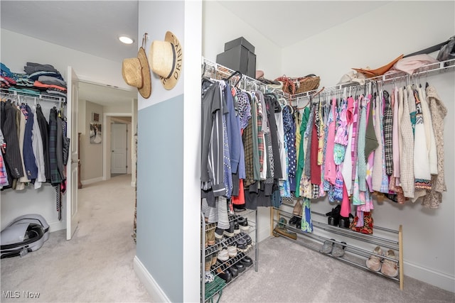 spacious closet featuring light colored carpet