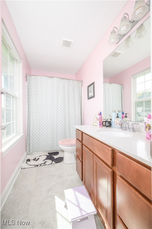 bathroom featuring vanity, toilet, curtained shower, and tile patterned flooring