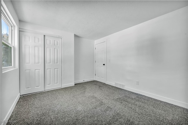 unfurnished bedroom with carpet flooring and a textured ceiling