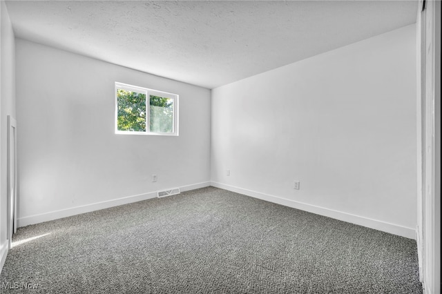 carpeted spare room with a textured ceiling