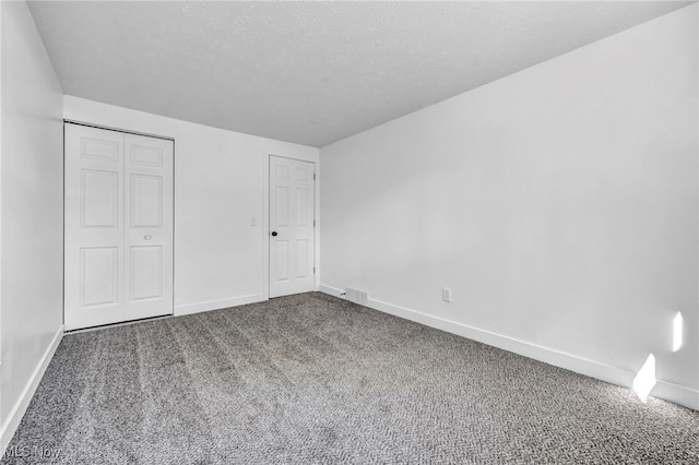 unfurnished bedroom featuring a closet, a textured ceiling, and carpet