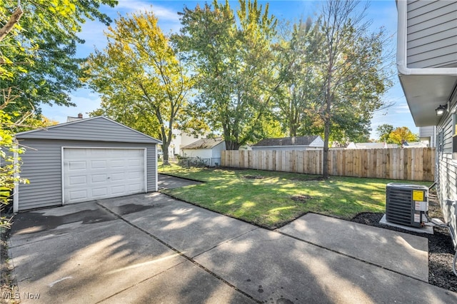 view of yard featuring a patio, a garage, cooling unit, and an outbuilding