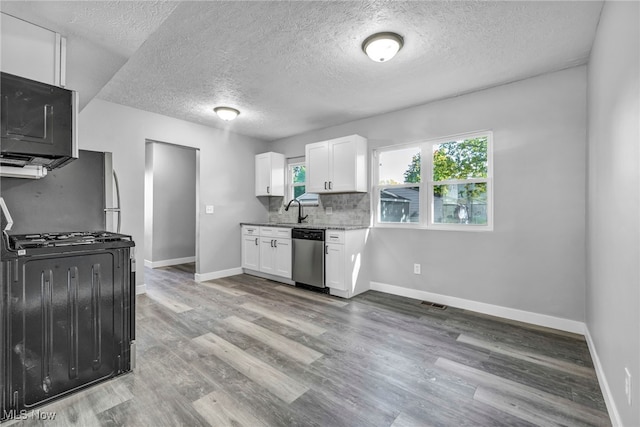 kitchen with stainless steel dishwasher, white cabinetry, wood-type flooring, and range