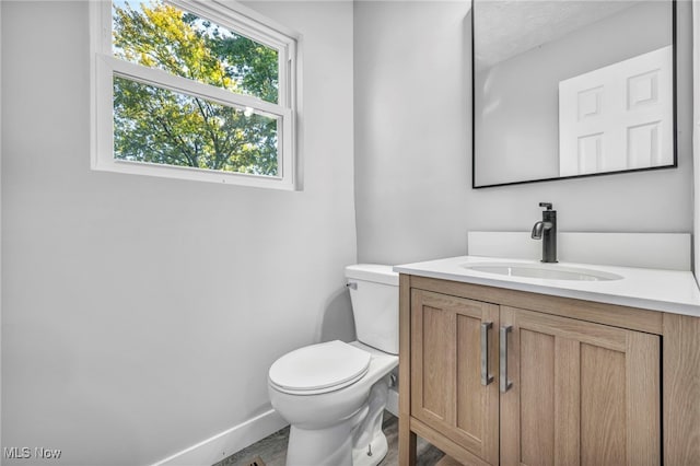 bathroom featuring vanity, toilet, and hardwood / wood-style flooring