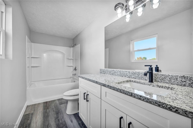 full bathroom featuring a textured ceiling, wood-type flooring, toilet, shower / bathtub combination, and vanity