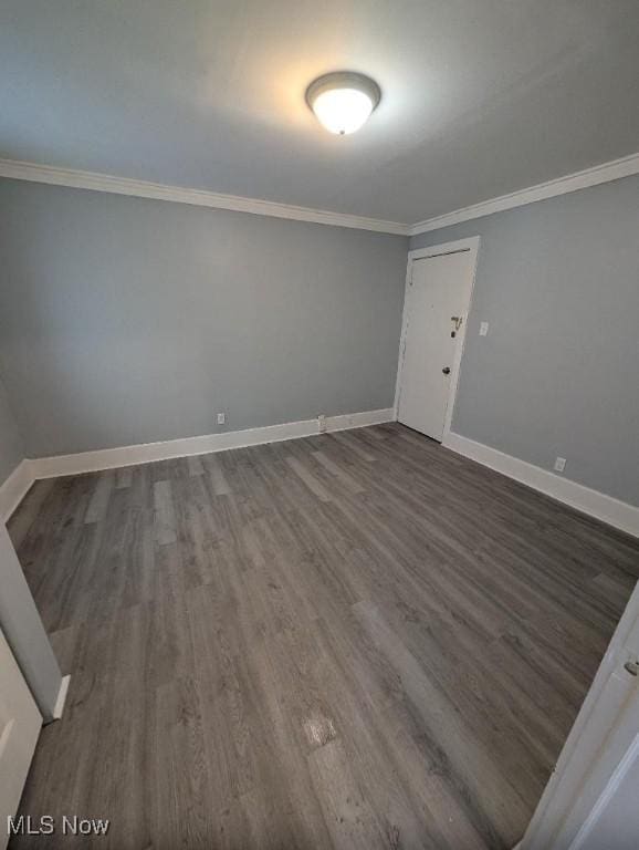 unfurnished room featuring crown molding and dark wood-type flooring