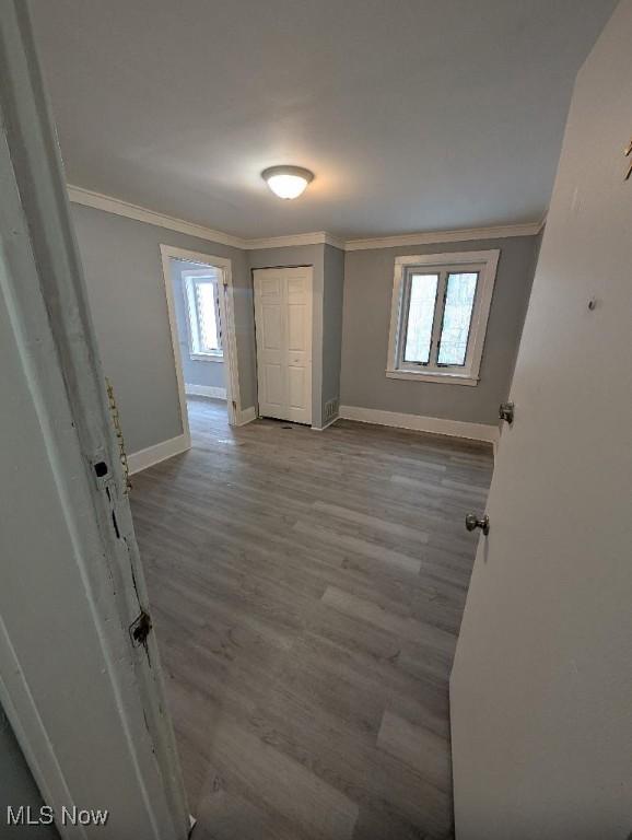 unfurnished room featuring hardwood / wood-style floors and crown molding
