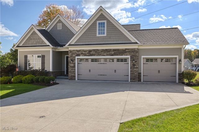 craftsman house with a front yard and a garage