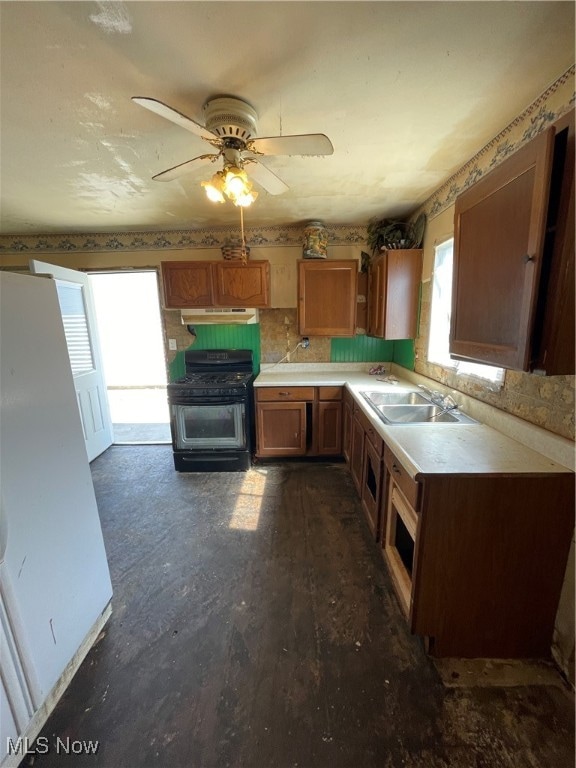 kitchen featuring black gas range, decorative backsplash, sink, and ceiling fan