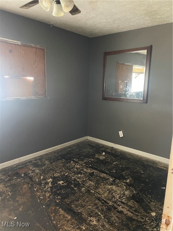 unfurnished room featuring ceiling fan and a textured ceiling