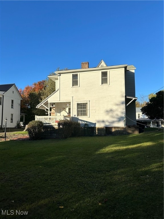 back of property featuring a yard