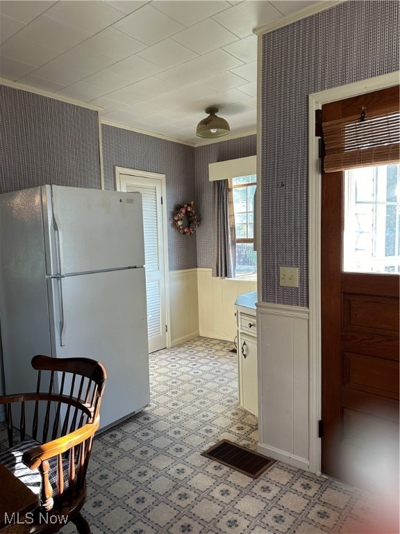 kitchen with crown molding, a healthy amount of sunlight, and white fridge