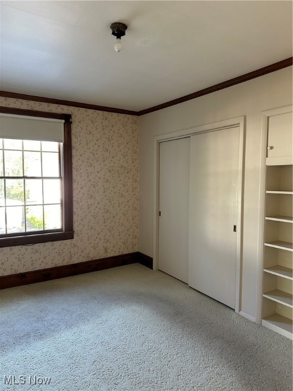 unfurnished bedroom with crown molding and carpet floors