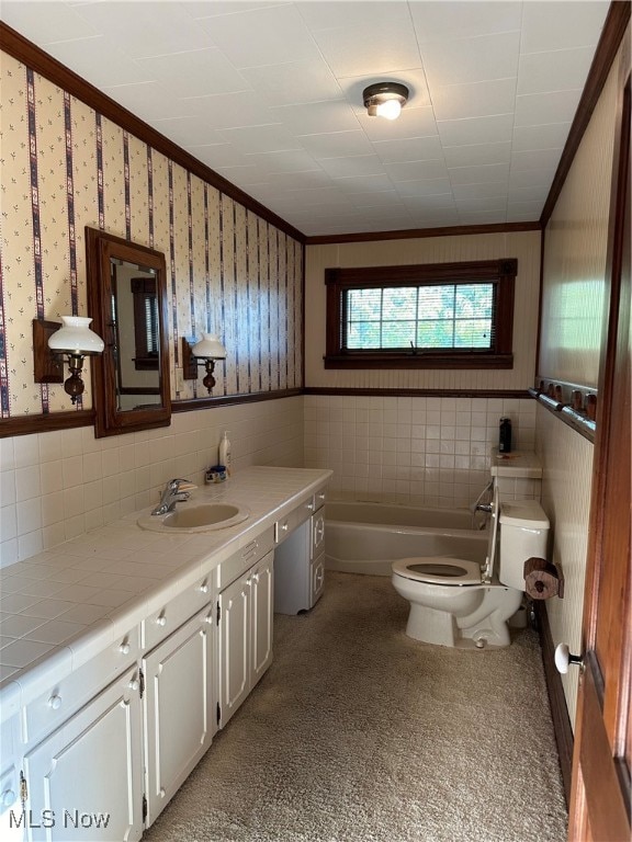 bathroom featuring toilet, a washtub, vanity, and tile walls