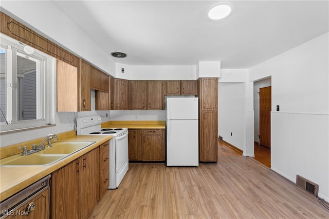 kitchen featuring white appliances, light hardwood / wood-style floors, and sink