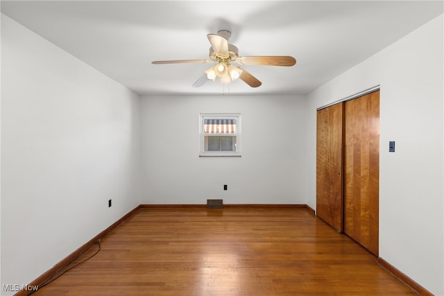 unfurnished bedroom featuring light hardwood / wood-style floors, a closet, and ceiling fan