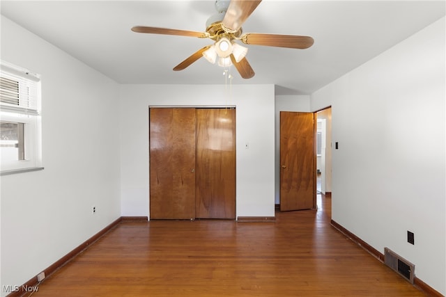 unfurnished bedroom featuring a closet, ceiling fan, and dark hardwood / wood-style floors