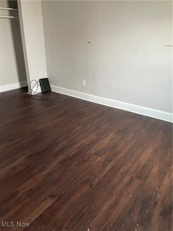 unfurnished bedroom with dark wood-type flooring