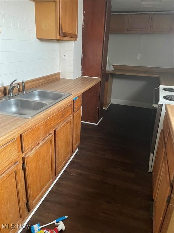 kitchen with sink, dark wood-type flooring, range hood, white range with electric stovetop, and backsplash