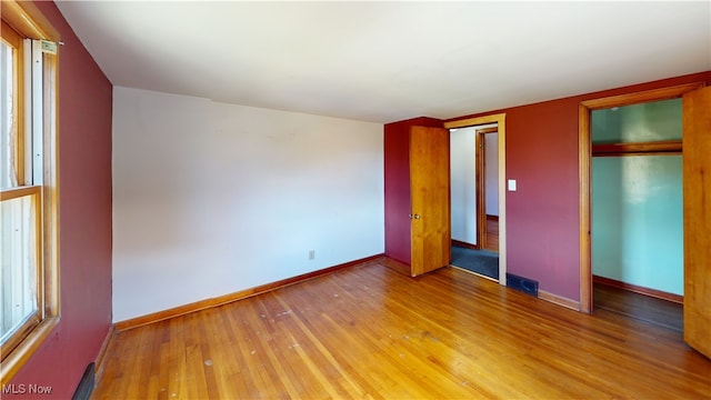 unfurnished bedroom with a closet and hardwood / wood-style flooring