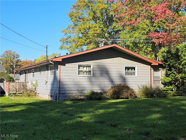 view of side of home with a lawn