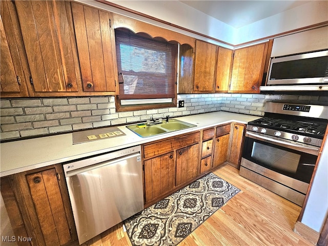 kitchen featuring light hardwood / wood-style flooring, appliances with stainless steel finishes, sink, and decorative backsplash