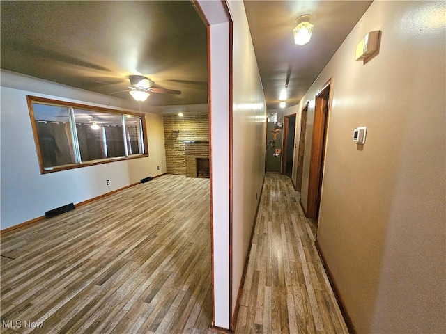 corridor with hardwood / wood-style flooring