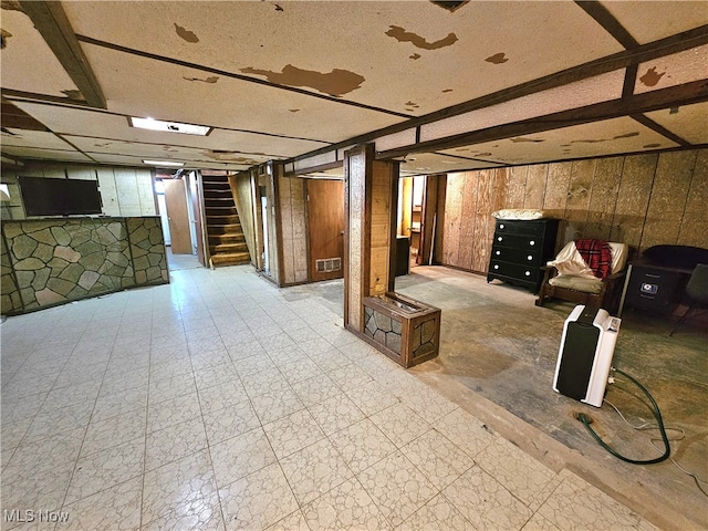 basement featuring wooden walls