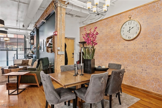 dining area with light hardwood / wood-style flooring and a notable chandelier