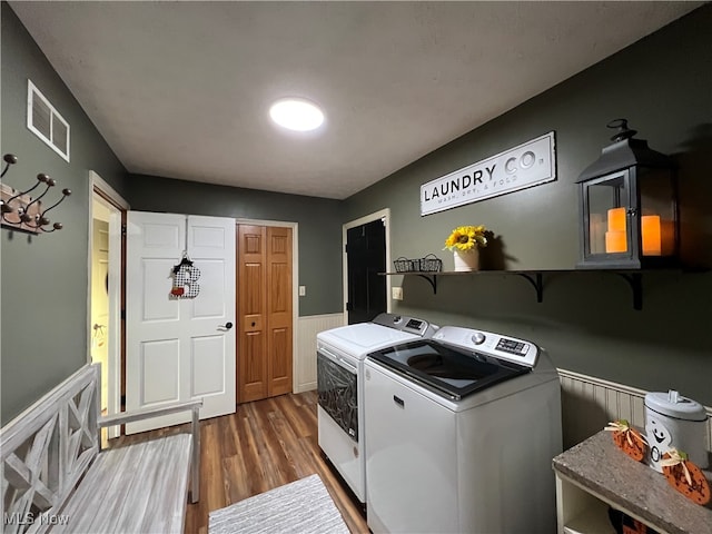 clothes washing area with dark wood-type flooring and washing machine and clothes dryer