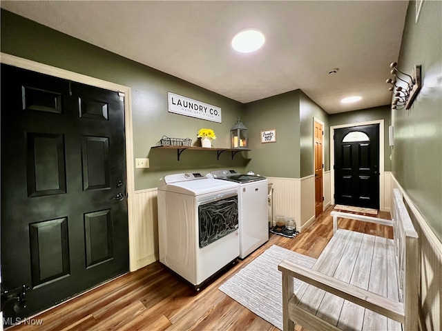 clothes washing area featuring light wood-type flooring and separate washer and dryer